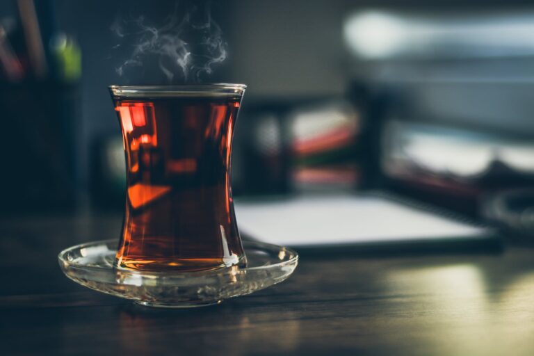 close up photo of steaming black tea in glass